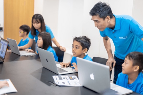 Teacher guiding students in coding class